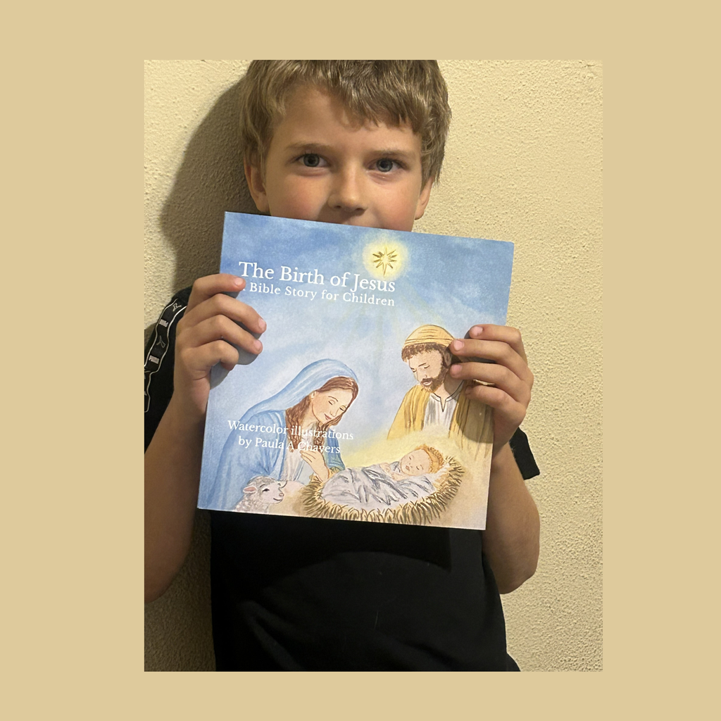 Child holding The Birth of Jesus watercolor children’s book by Paula A. Chavers