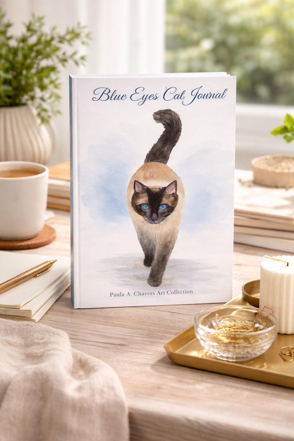 Blue Eyes Cat Journal mockup featuring original Siamese cat watercolor artwork by Paula A. Chavers, displayed on a cozy desk with soft neutral decor, books, candles, and warm natural lighting.