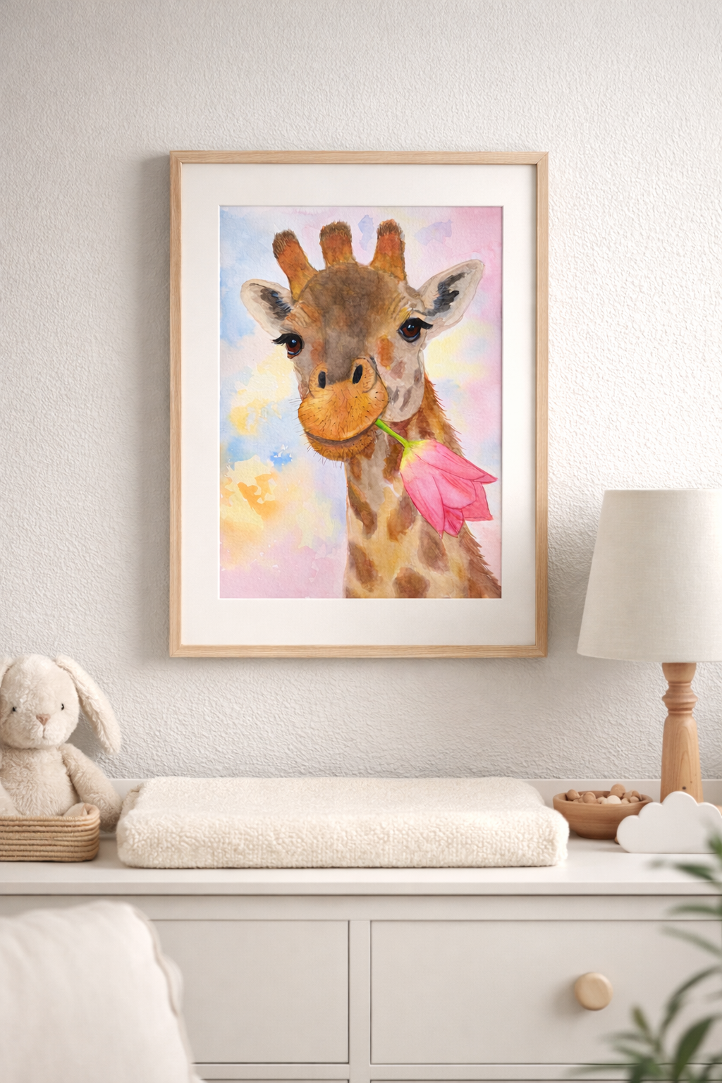 Original giraffe watercolor painting by Paula A. Chavers displayed in a soft neutral nursery with light wood decor, cozy styling, and elegant framed presentation.